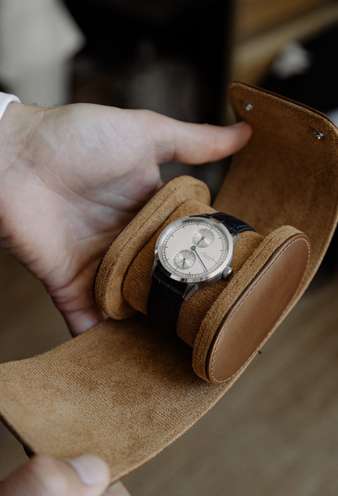 A silver-dialled Ascanbe with two subdials, resting in a leather watch roll