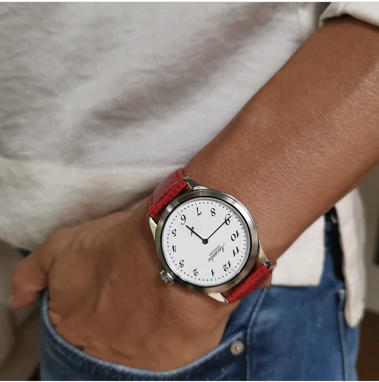 The very first Ascanbe: a white dial with hand-drawn numerals on a red strap